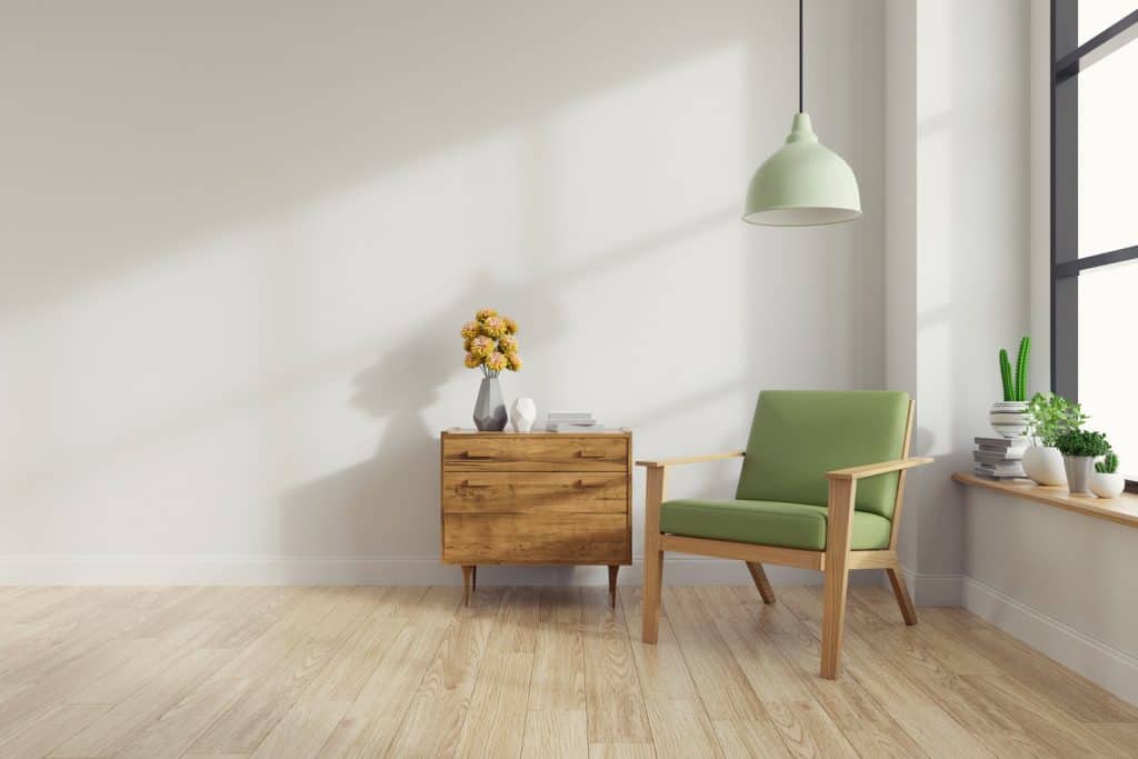 Modern mid Century and vintage interior of living room ,green lounge chair with wood table on white wall and cherry wood floor in front of a window 