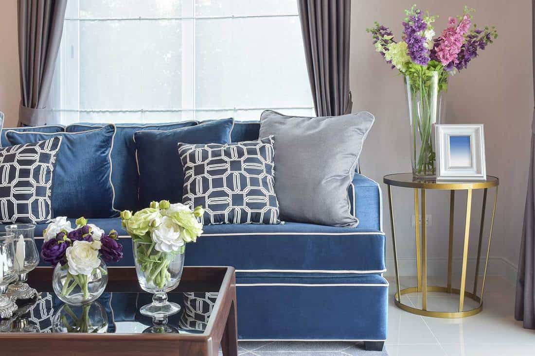 Navy blue modern classic sofa set with beautiful flower vases in nice living corner