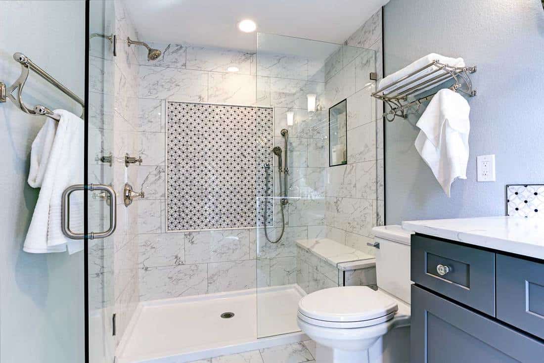 Nouveau design de salle de bain bleu avec contour de douche en marbre et carreaux d'accent en mosaïque