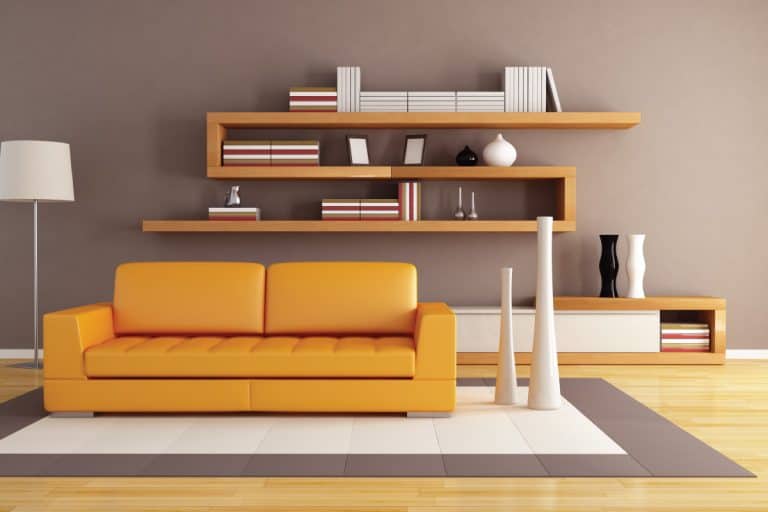 Orange and brown living room with brown abstract floating shelf. 22 Great Wall Shelving Ideas