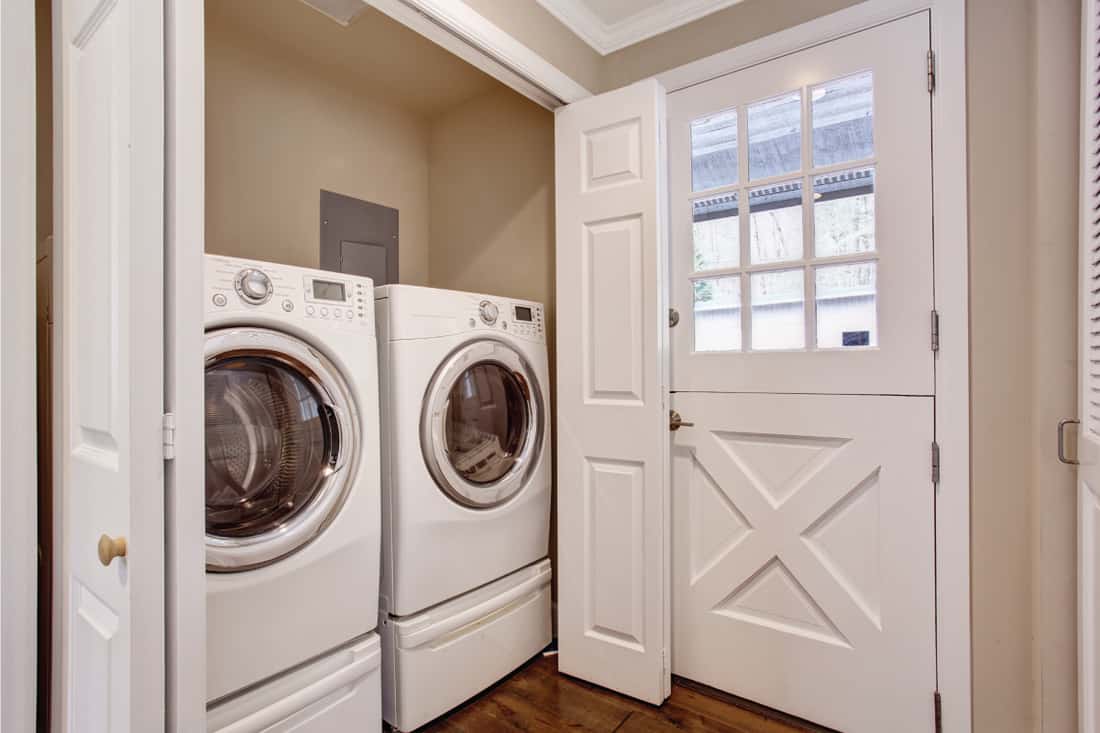 Small laundry area with washer and dryer and white door with vents. Does A Laundry Room Need A Door