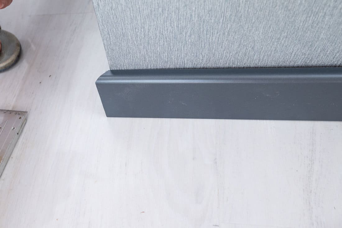 The plinth is dark gray to match the color of the door, mounting the plinth in the room, light gray floor and dark plinth. 