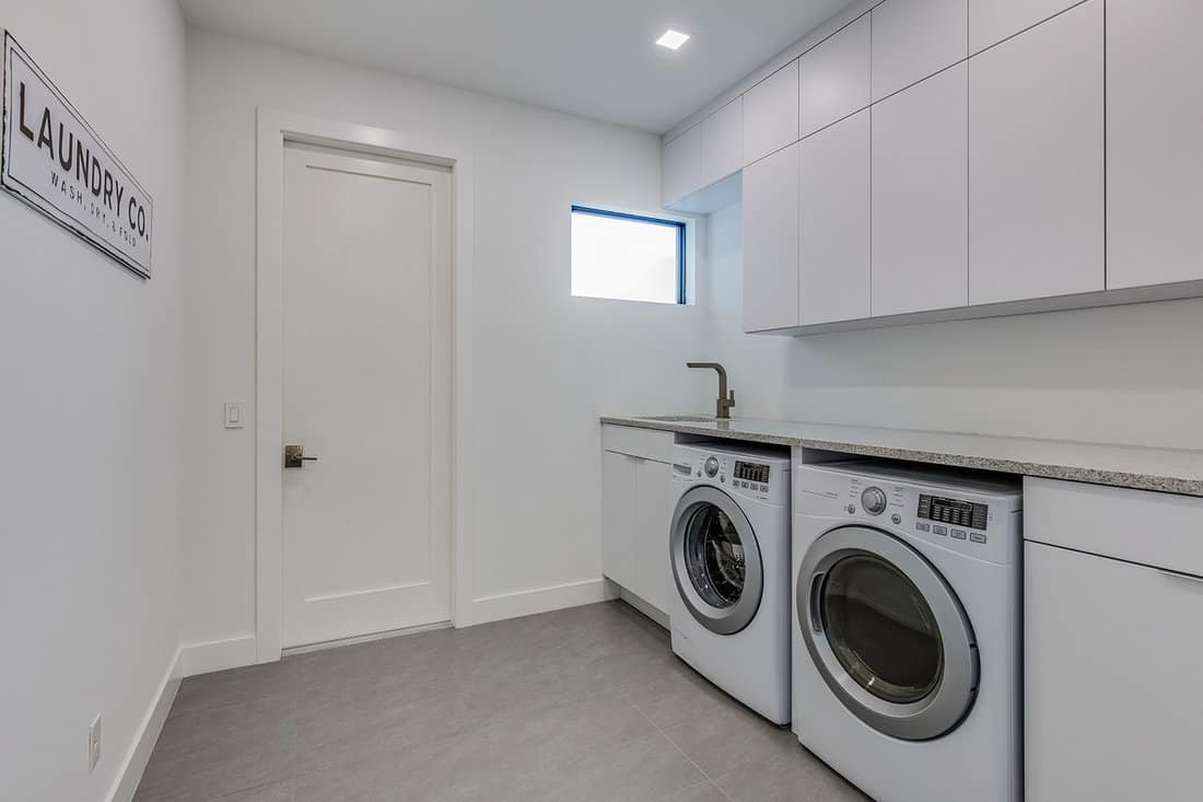 White laundry room with brand new washing machine and dryer