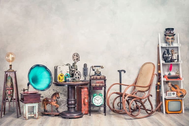 Teddy Bear toy on chair, typewriter, vintage gramophone, old books, radio, globe, binoculars, carnival mask, camera, fiddle on shelf, steering wheel, plane, travel backpack, bow and other furniture used items, Where And How To Sell Secondhand Furniture