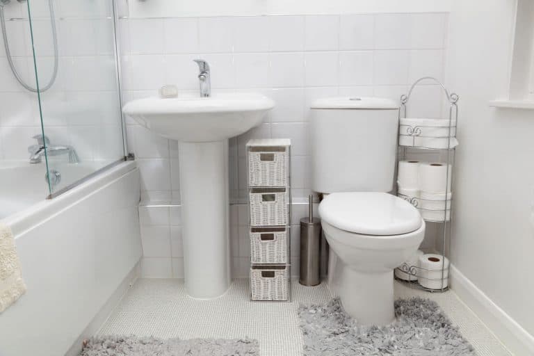 Interior of a modern bathroom with a rug under the toilet and a mirror on the wall, Do Toilets Use Electricity?