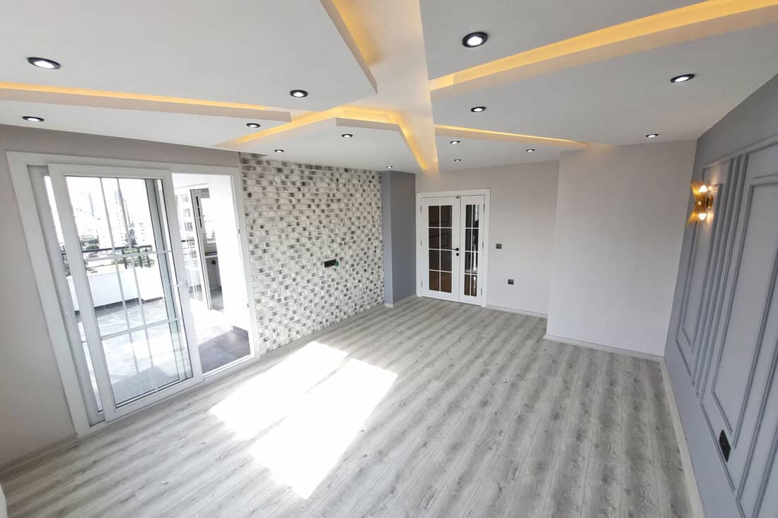 patterned suspended ceiling, spot lights, gray and stone patterned walls, a large living room