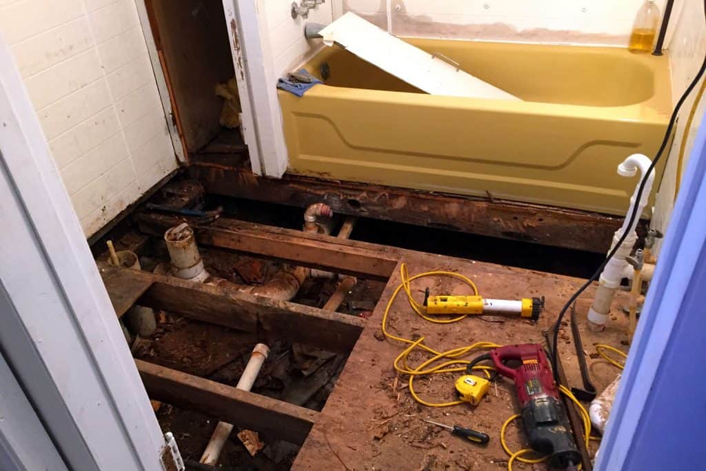 A bathroom under construction with different equipment's laid on the unfinished floor