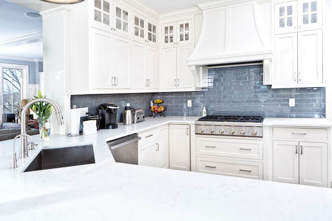 Une cuisine maison contemporaine avec des appareils électroménagers en acier inoxydable et des armoires peintes en blanc