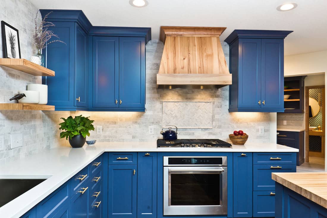 A contemporary kitchen renovation remodeling featuring a center island, hardwood floor and quartz counter, Where Does A Backsplash End - At The Cabinets Or Countertops?