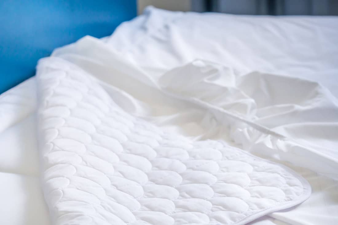 A mattress cover inside a blue colored bedroom, Should You Wash A Mattress Cover Before Using It?