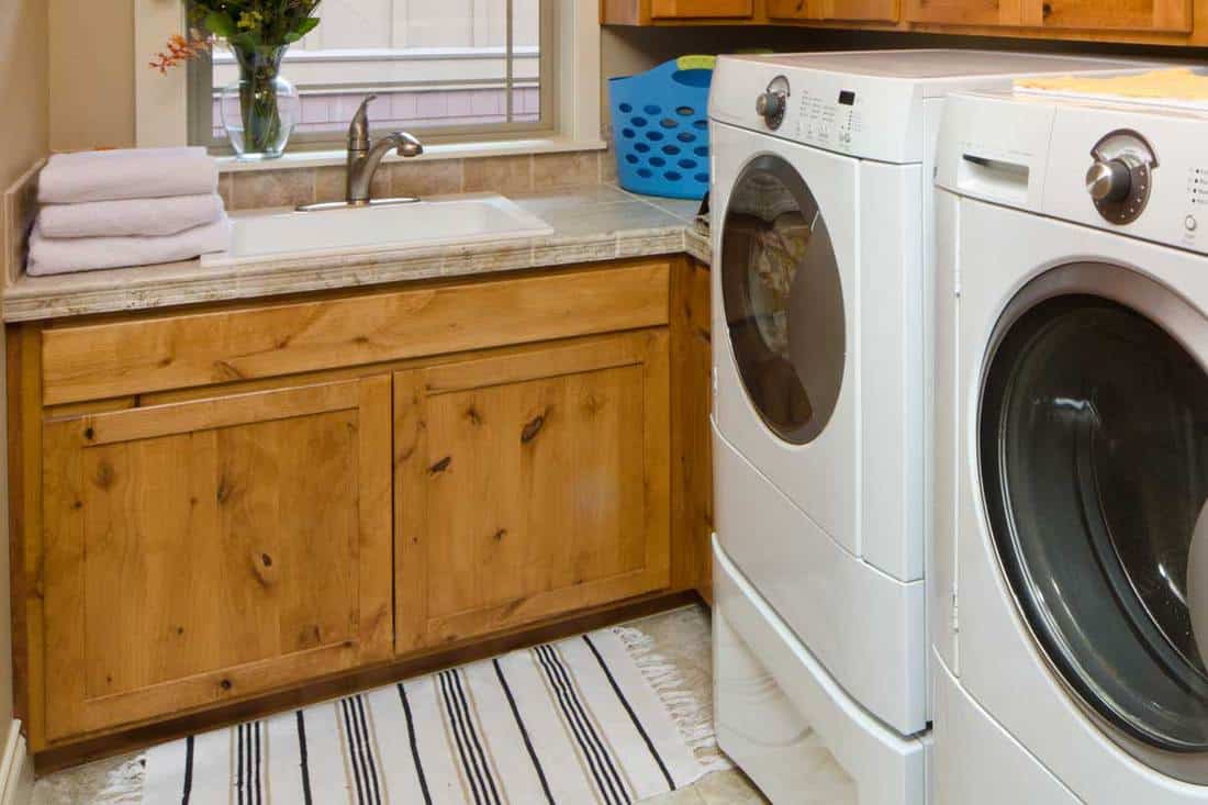 A modern laundry room with front loaders and wooden cabinets, 10 Best Rugs For Your Laundry Room
