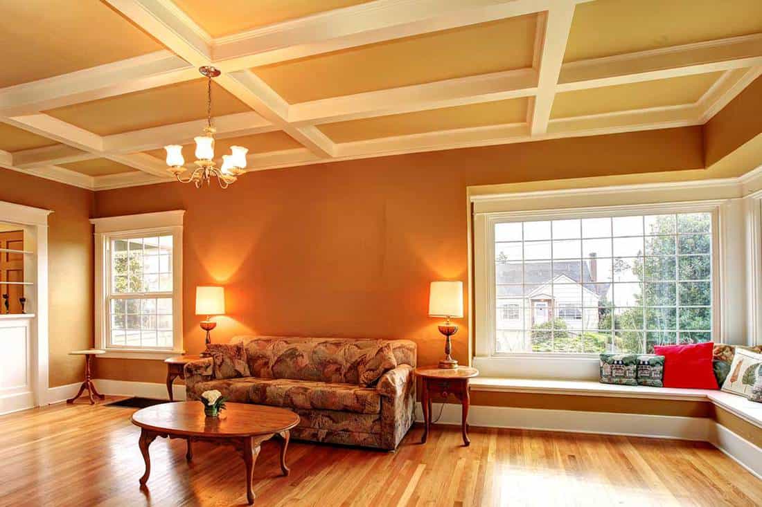 A modern living room with a coffered ceiling and hardwood floor, How Deep Should A Coffered Ceiling Be?