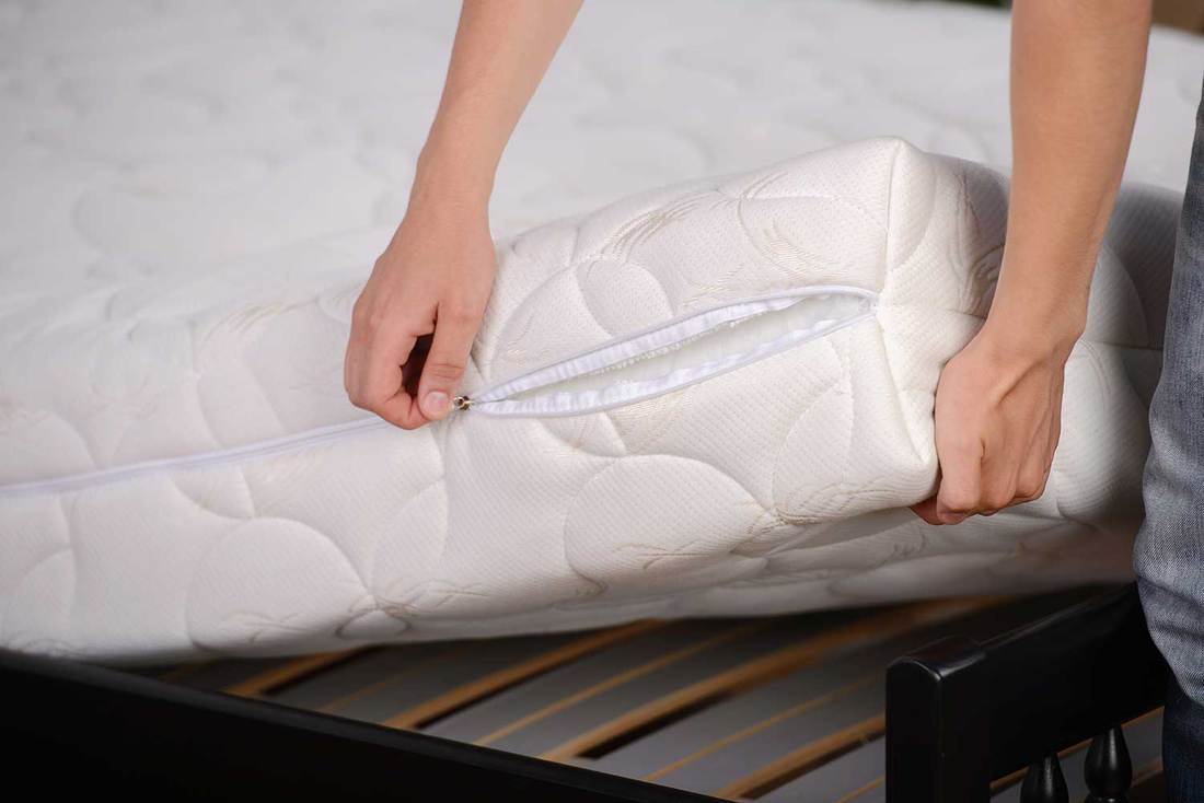 A person removing mattress cover to be washed