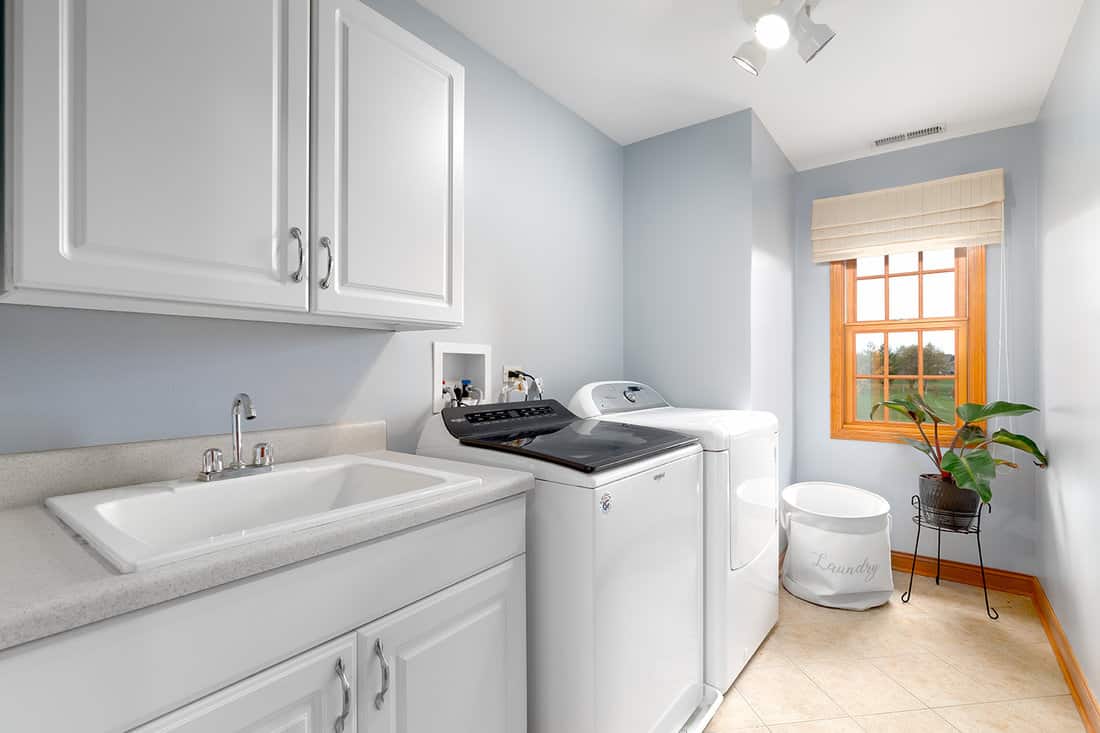 A renovated laundry room with a white utility sink