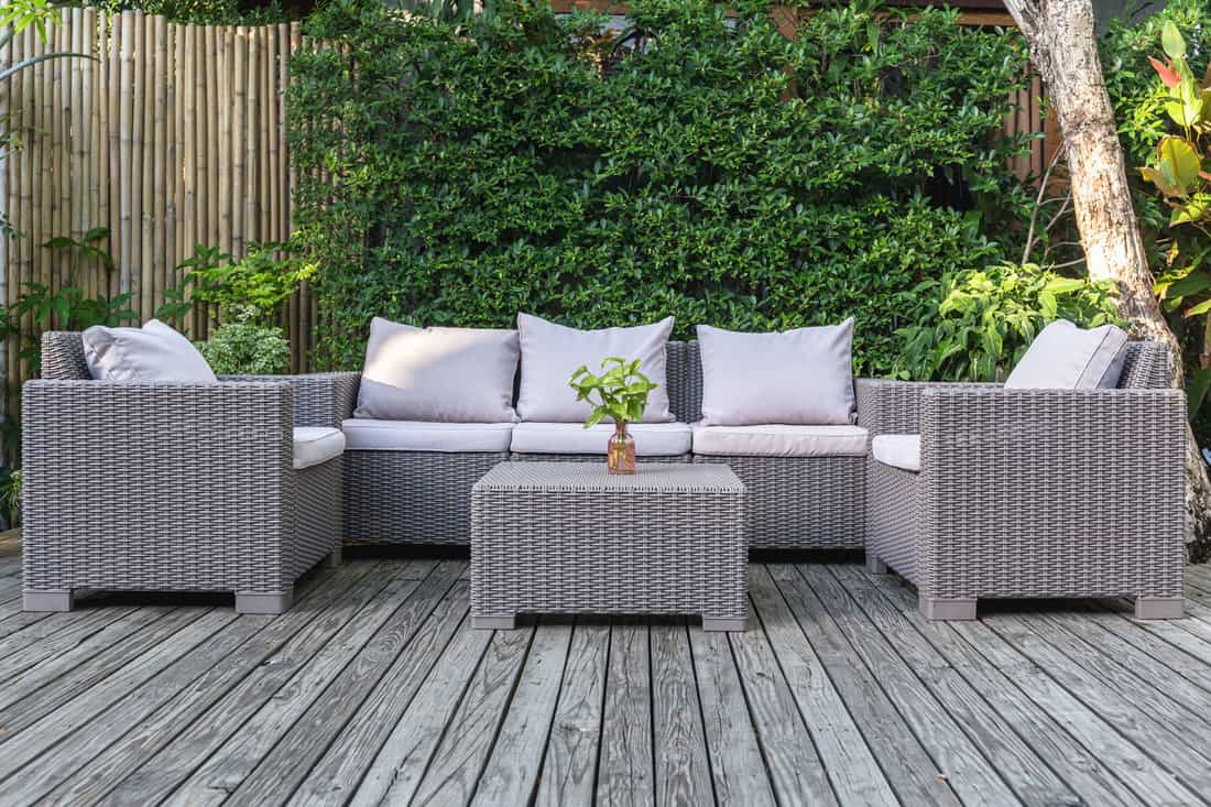 A set of Rattan chairs outdoor with throw pillows and a coffee table on the center, 4 Ways To Keep Cushions On Outdoor Furniture
