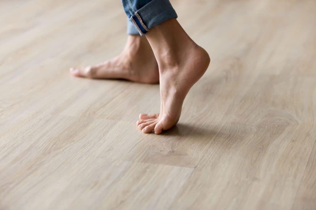 A woman walking on a laminated flooring in an apartment