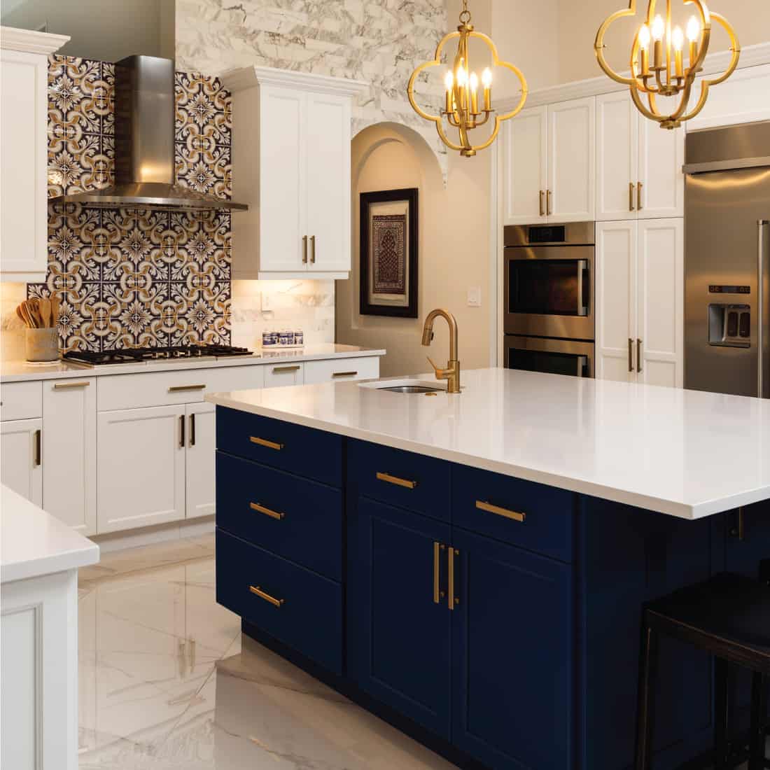 Beautiful luxury estate home kitchen with white cabinets. italian gold accented backsplash