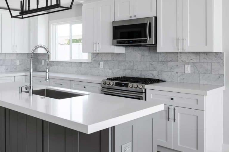 Beautiful modern kitchen with white cabinets and countertops, How High Do You Tile A Kitchen Backsplash?