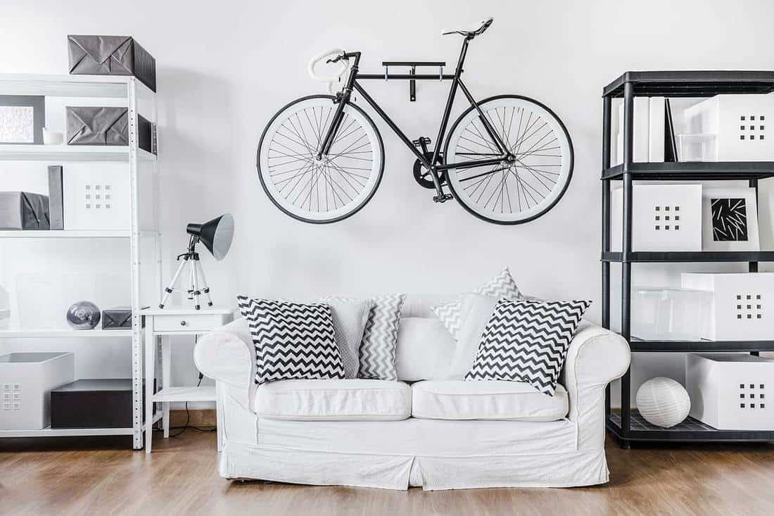 Black and white contemporary living room interior with bike hanging on wall