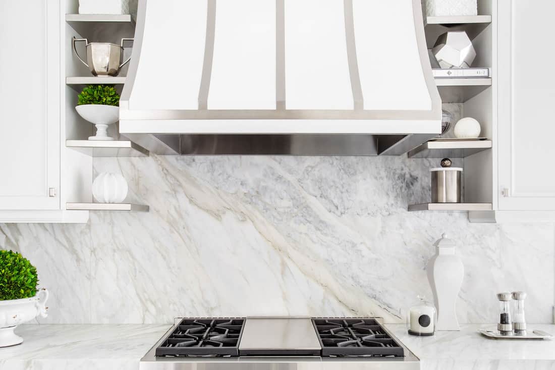 Bright horizontal image of classic white kitchen, with gas range and marble backsplash, How To Clean A Marble Backsplash In 6 Simple Steps