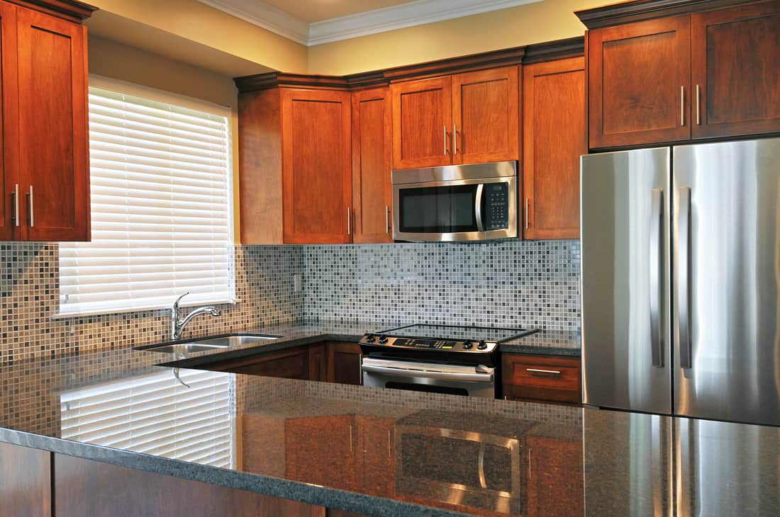 Bright modern kitchen with gorgeous backsplash and oak cabinets