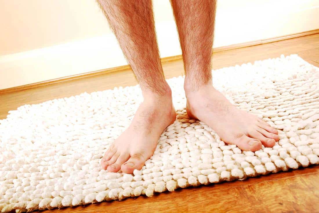 Close up of a man's hairy legs after a shower