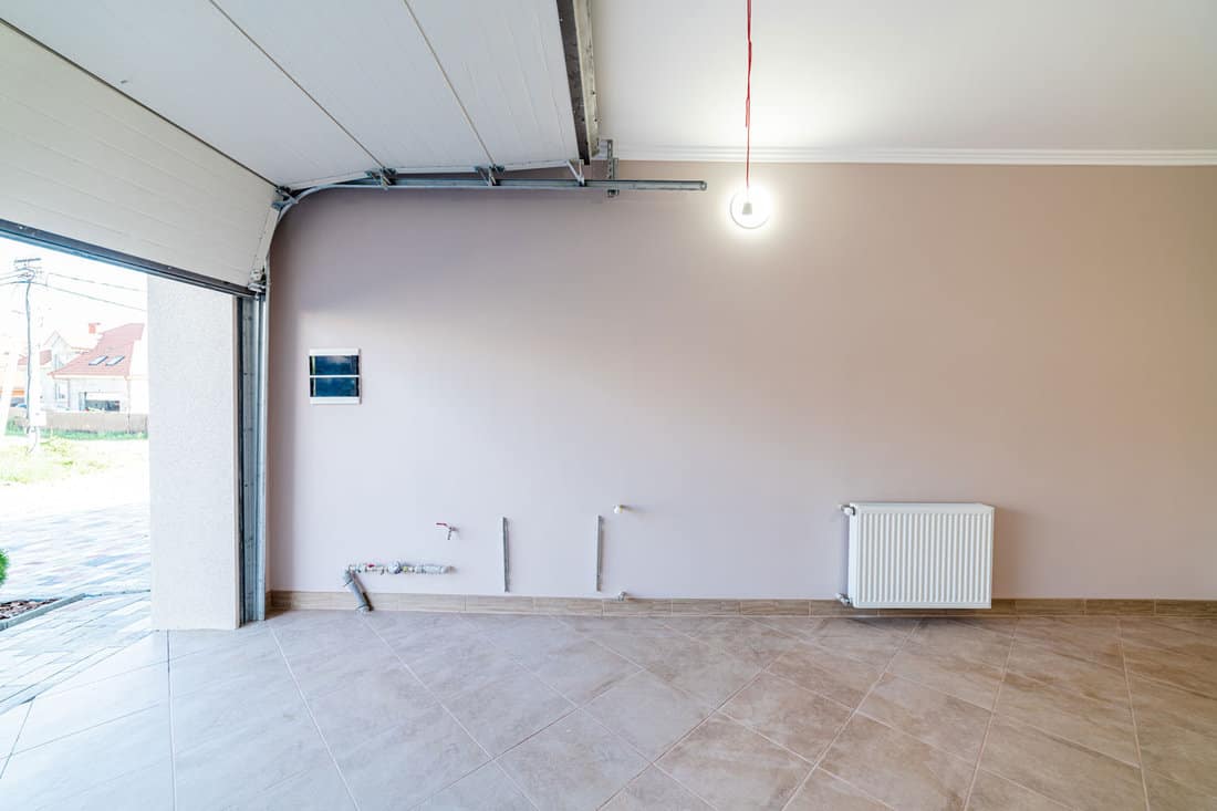  Empty bright garage for a car with electric gates, and heating equipment and a separate entrance to the house.