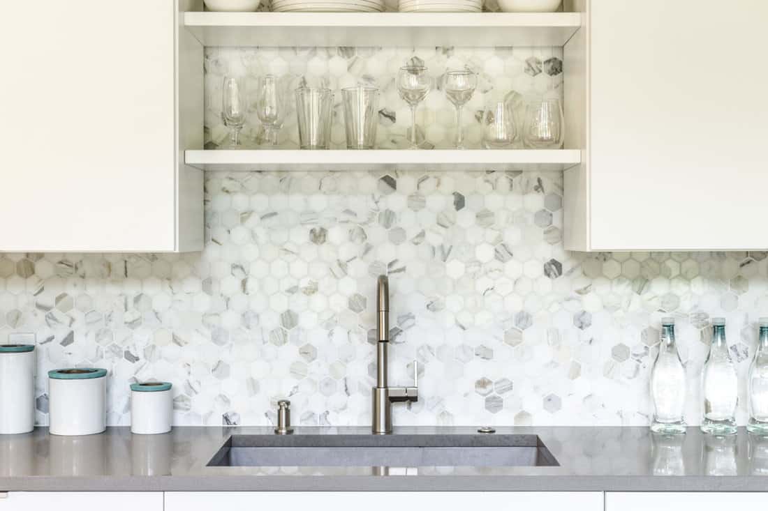 Gorgeous white hexagonal tile backsplash and gray countertop