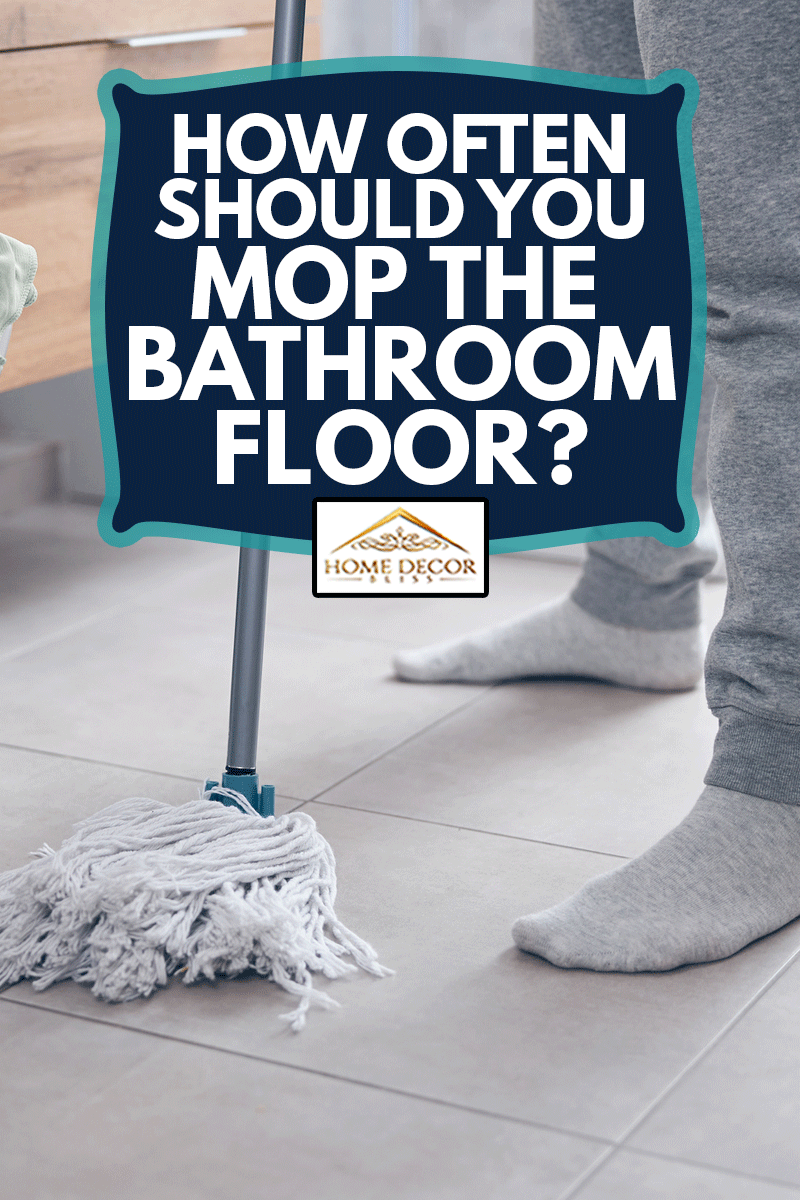 Photo recadrée d'un homme moderne debout sur le sol d'une cuvette de toilette en céramique essuyant le sol de la salle de bain, À quelle fréquence devriez-vous essuyer le sol de la salle de bain ?