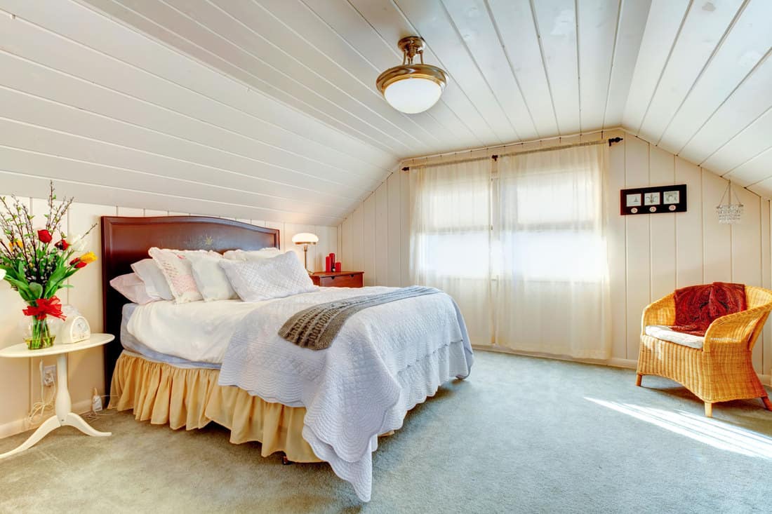 Interior of a mansard bedroom with wooden ceilings and sidings
