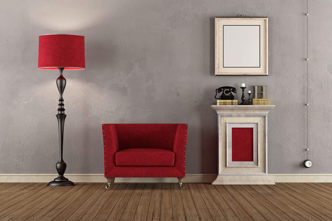 Interior of a modern living room with a gray wall, red chair, and a tall floor lamp on the side