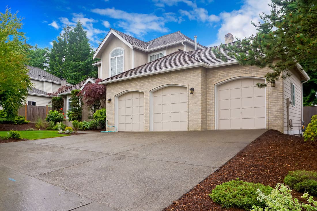 Large beige house with three car garage and large driveway