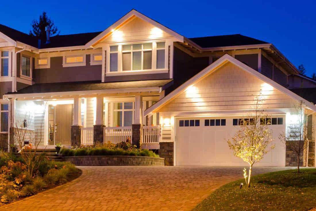 Luxury house at dusk with outdoor lights on, Should Garage Lights Match Porch Lights?