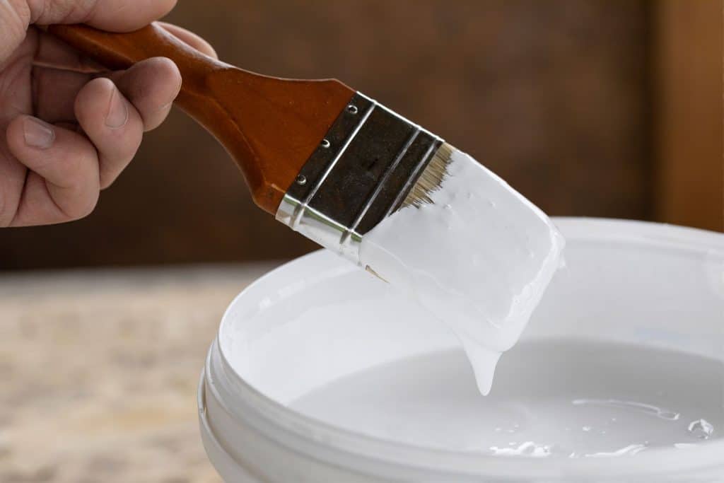 Man holding a brush with white paint