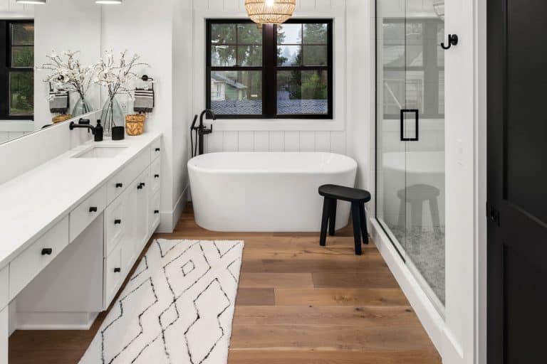Master bathroom interior in new farmhouse style luxury home large mirror, shower, and bathtub, 7 Tips To Keeping A Bathroom Floor Dry After Showering