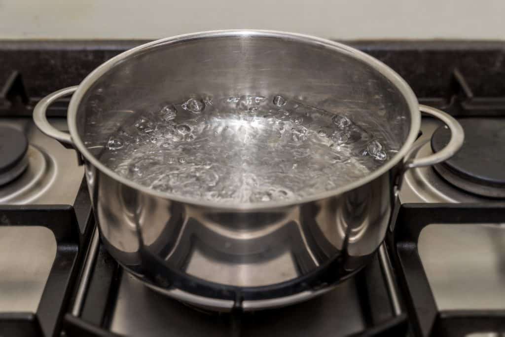Casserole de cuisson en métal avec de l'eau bouillante et sur une cuisinière, une cuisinière