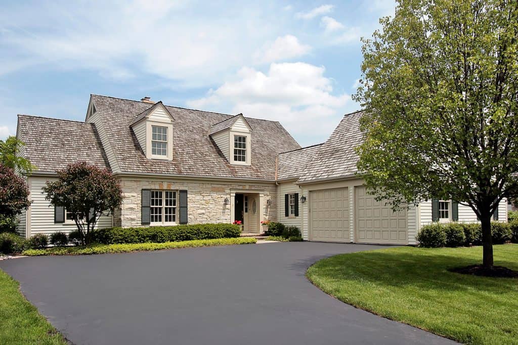Stone home with cedar roof and wide driveway