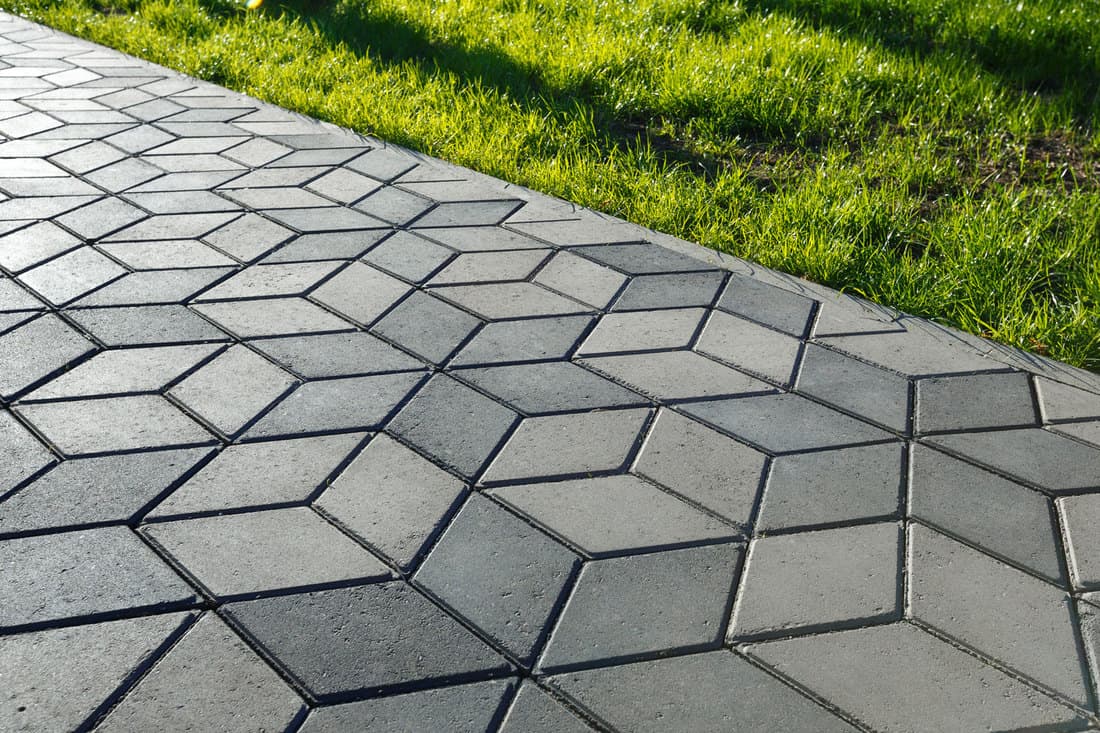 The footpath in the park is paved with diamond shaped concrete tiles, How Thick Should Driveway Pavers Be? [And Should You Seal Them?]
