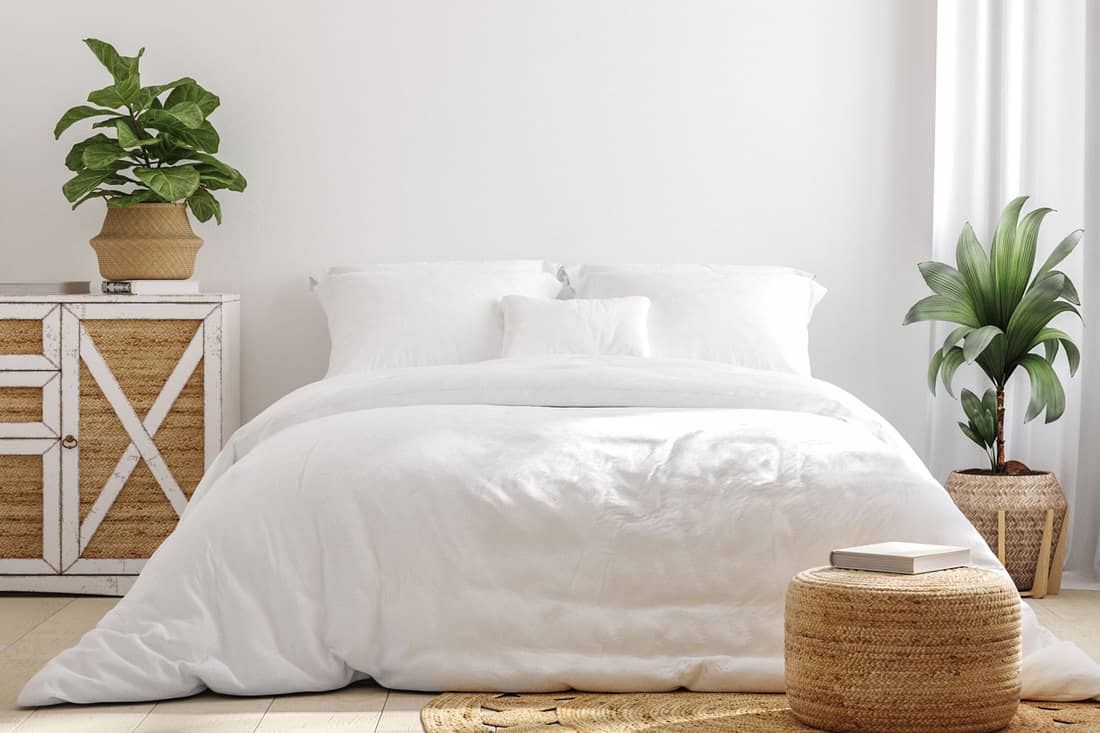 White cozy farmhouse bedroom interior, with long and narrow white comforter, How To Hide A Box Spring - Even Without A Bed Skirt!