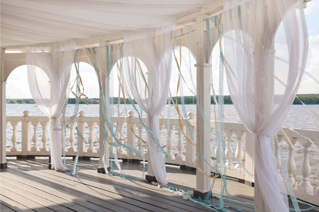 White porch with arches on the shore of the lake. 11 Porch Blinds Ideas For An Enjoyable Outdoor Experience