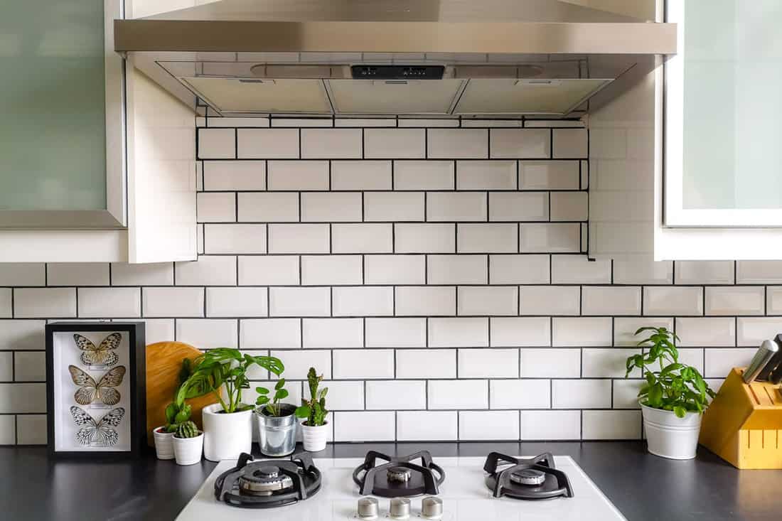 White runway tile backsplash and dark black kitchen countertop
