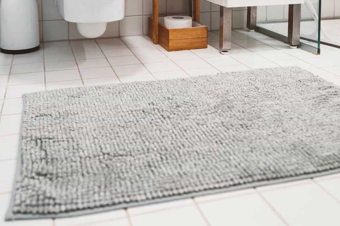 White tiles in a modern small bathroom with gray bath mat, 8 Best Non-Slip Bathroom Floor Mats For Elderly