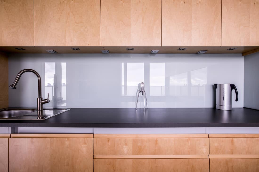 Close up indoor shot of modern clean domestic kitchen design with beige backsplash