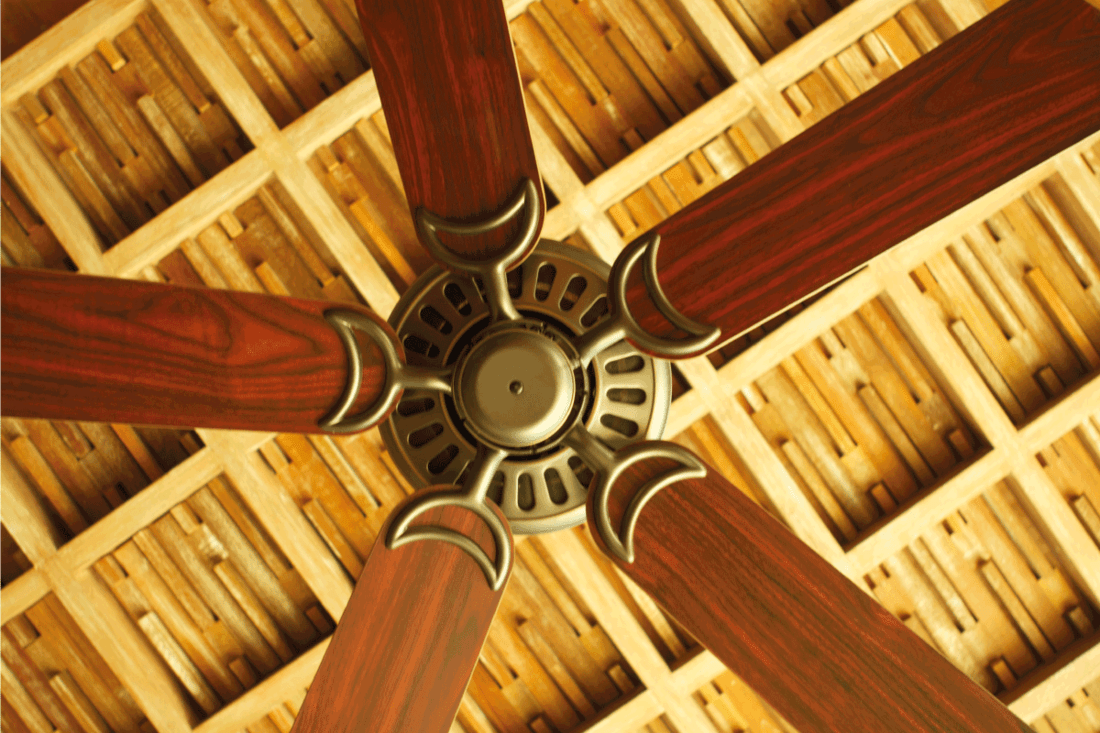image of a ceiling fan in a holiday hotel resort with wood blades. How Many Porch Ceiling Fans Do You Need