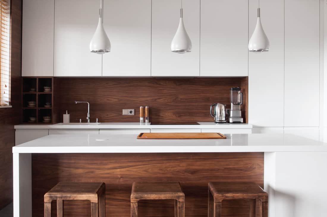 wood design kitchen with quartz countertop and textured wood backsplash