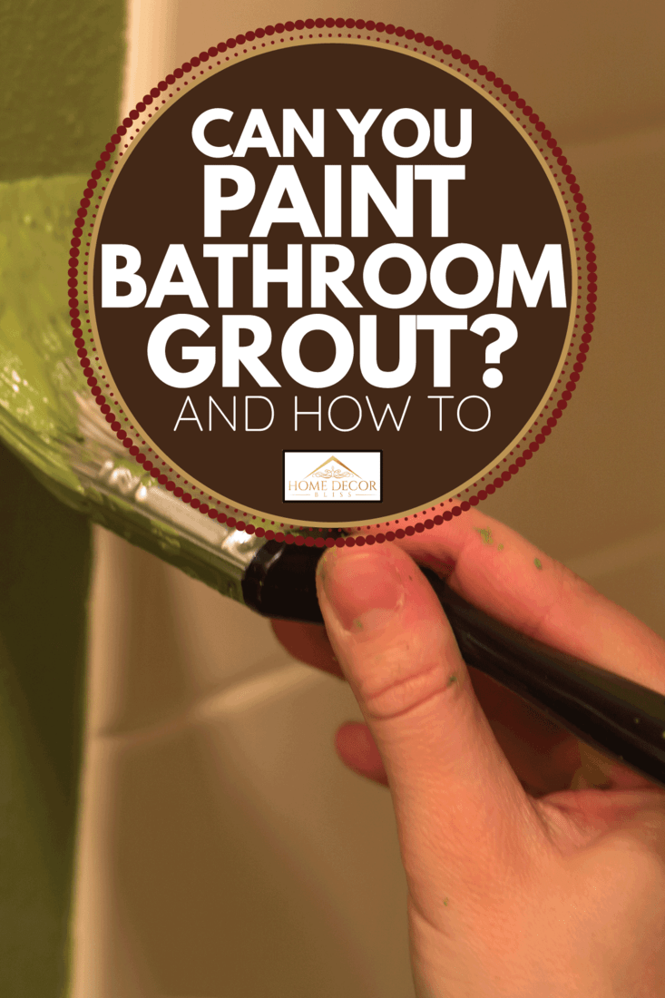 A hand holding a paint brush and painting with green paint. Tile in background. Can You Paint Bathroom Grout [And How To]