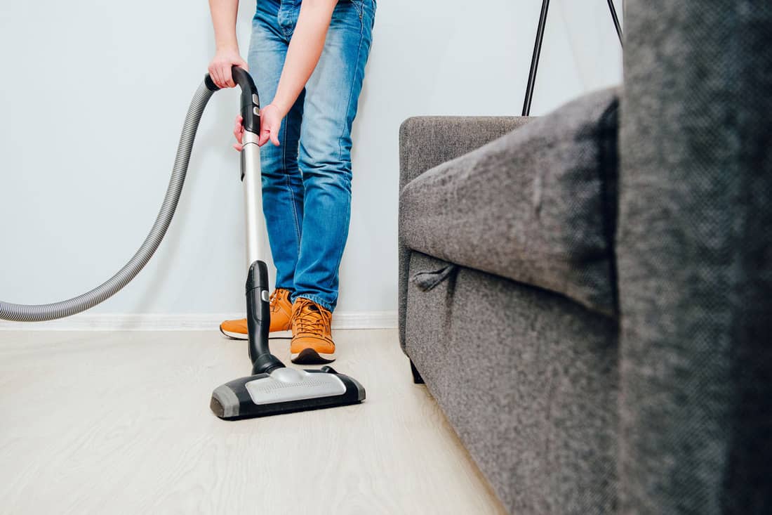 A man uses a vacuum cleaner to clean the apartment. Concept of caring for the interior of the apartment, cleaning. Help husbands in housekeeping, Can You Use Bleach Or Other Cleaners In A Bissell Crosswave?
