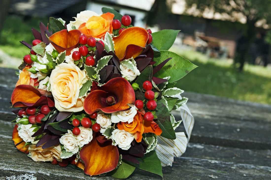 Beautiful wedding bouquet using white roses, leaves, and berries, 15 Awesome Lily Flower Arrangements