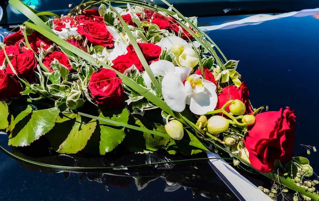 Car jewelry heart with red roses and white orchids for wedding
