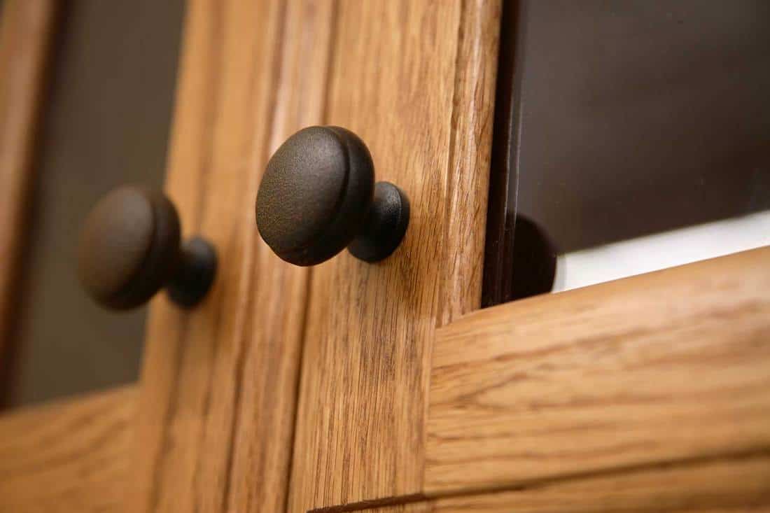 Close-up of a kitchen cabinet door knob in wood